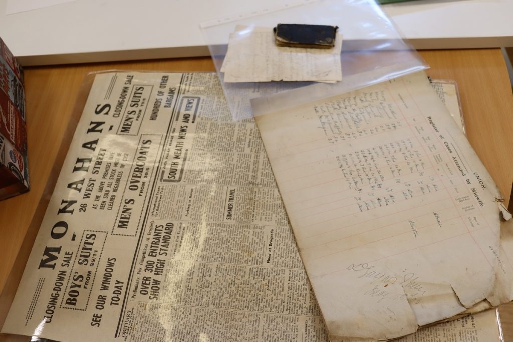 Photograph from the Collection day, showing an early 20th century newspaper and a set of medical records.