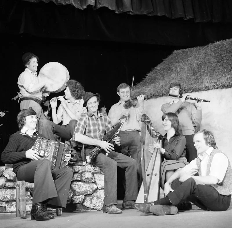 An Irish traditional band performing on stage with instruments such as the harp, tin whistle, accordion, baron, fiddle, uilleann pipes at the National Folk Theatre, Siamsa Tíre in Tralee, County Kerry.