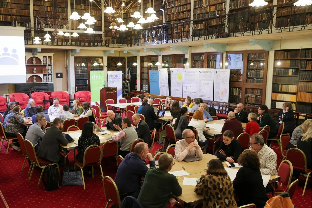 Attendees of the NORF Workshop sitting at tables in the Meeting Room of the Royal Irish Academy, discussing the topics of the day.