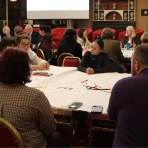 Attendees of the 'Reform of Research Assessment: Impact on Doctoral Students' workshop sitting at discussion tables in the Meeting Room of the Royal Irish Academy on 5 November 2024.